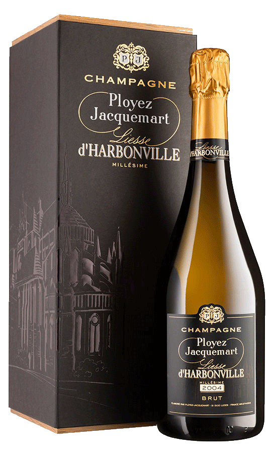 Taça de Champagne Ployez-Jacquemart Liesse D'Harbonville 2004 Brut com garrafa de champagne ao fundo.
