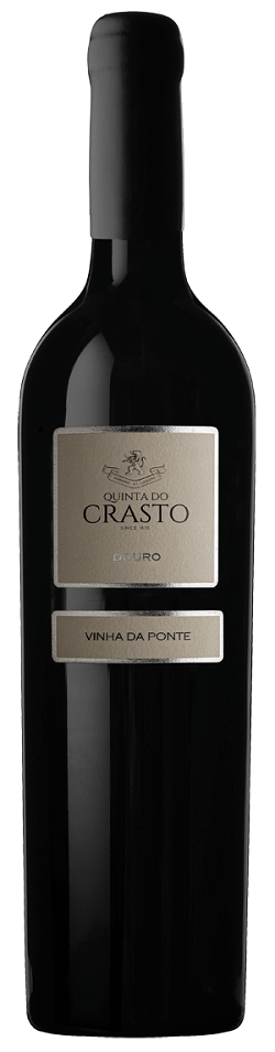Taça de vinho tinto Quinta do Crasto Vinha da Ponte, safra 2018, com garrafa ao fundo, em ambiente elegante.