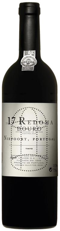 Taça de vinho tinto Redoma da Niepoort, com garrafa de vinho tinto Redoma 2021 ao fundo, destaque para rótulo e cor do vinho.