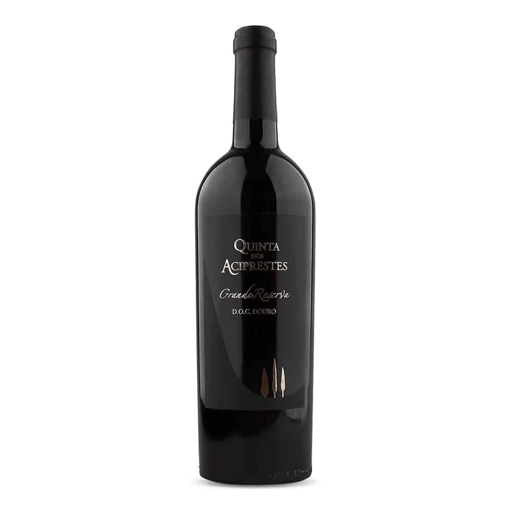 Taça de vinho tinto Aciprestes Grande Reserva Real Companhia Velha, garrafa de vinho tinto de 2015, na adega.