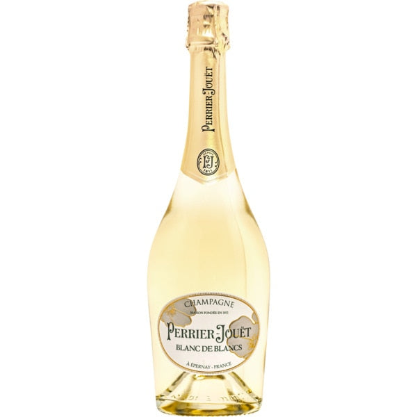 Taça de champagne Perrier Jouet Blanc Blanc com garrafa de champagne Perrier Jouet ao fundo, em ambiente elegante