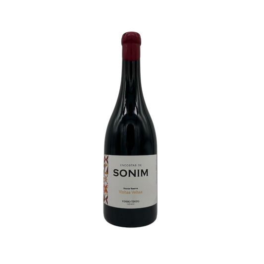 Taça de vinho tinto Encostas de Sonim Vinhas Velhas, garrafa de vinho Sonim, destaque para rótulo elegante e cor do vinho.