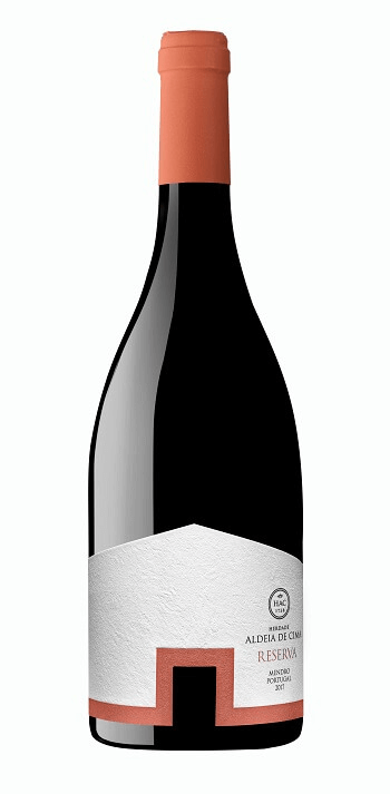 Taça de vinho tinto Herdade Aldeia de Cima Reserva com garrafa ao fundo, destaque para o rótulo do vinho de 2020.