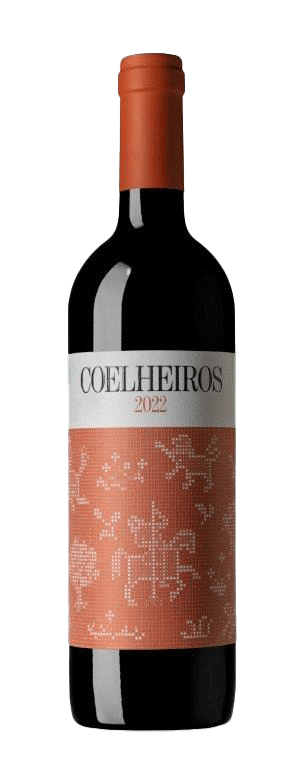 Taça de vinho tinto Herdade dos Coelheiros Colheita Tinto 2022, com garrafa ao fundo, destacando a cor do vinho.