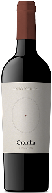 Taça de vinho tinto Grainha Reserva Quinta Nova, garrafa de vinho tinto vinho de 2023, visível na imagem.
