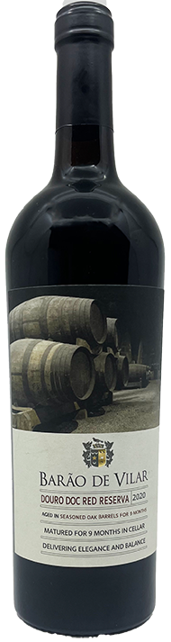 Taça de vinho tinto Barão de Vilar Reserva, vinho português da marca Van Zeller, com garrafa de vinho tinto na imagem.