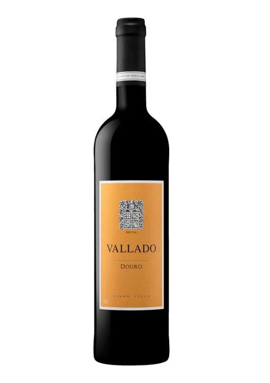 Taça de vinho tinto Quinta do Vallado, com garrafa de Vallado Tinto 2023 ao fundo, em ambiente elegante e sofisticado.