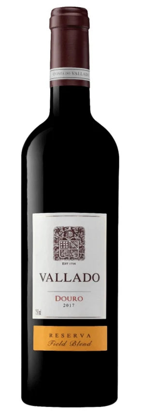 Taça de vinho tinto Vallado Reserva Tinto Quinta do Vallado, com garrafa na mesa, destaque para rótulo e cor do vinho.