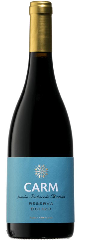 Taça de vinho tinto Carm Reserva Tinto 2022, destaque para a cor rubi e detalhes do rótulo na garrafa.