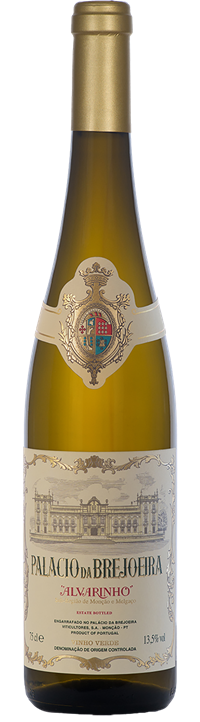 Taça de vinho verde Alvarinho Palacio da Brejoeira com garrafa de vinho branco na mesa, destaque para o rótulo.