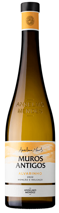 Taça de vinho Alvarinho Muros Antigos Vinho Verde da marca Anlselmo Mendes, com garrafa ao fundo.