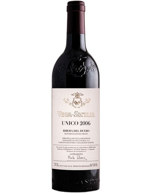 Taça de vinho tinto com garrafa de Vega Sicilia Único, vinho do mundo da marca Vega de Sicilia, em ambiente elegante