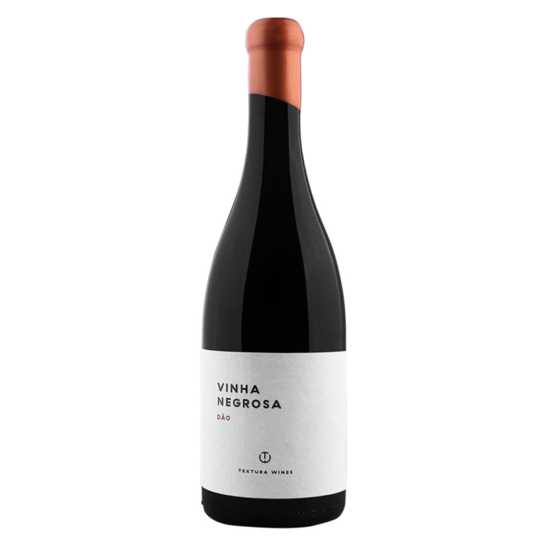 Taça de vinho tinto Vinha Negrosa da marca Textura, com garrafa de vinho tinto ao fundo, em ambiente elegante.