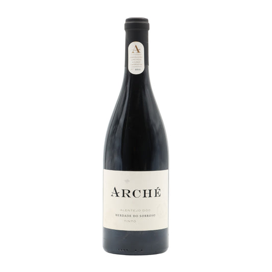 Taça de vinho tinto Herdade Sobroso Arche 2022, com garrafa de vinho vermelho na mesa.